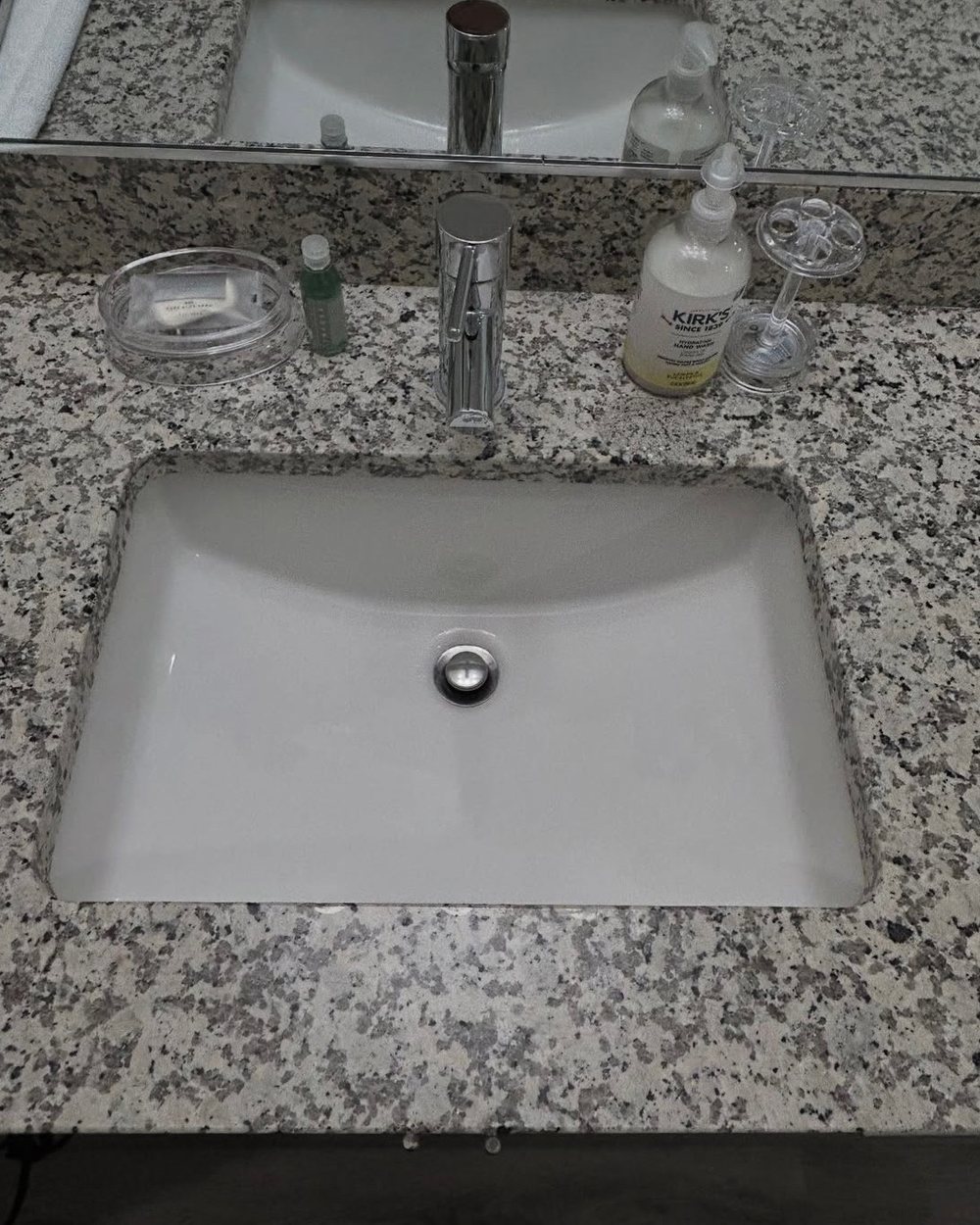 A polished granite counter and porcelain sink after detail cleaning